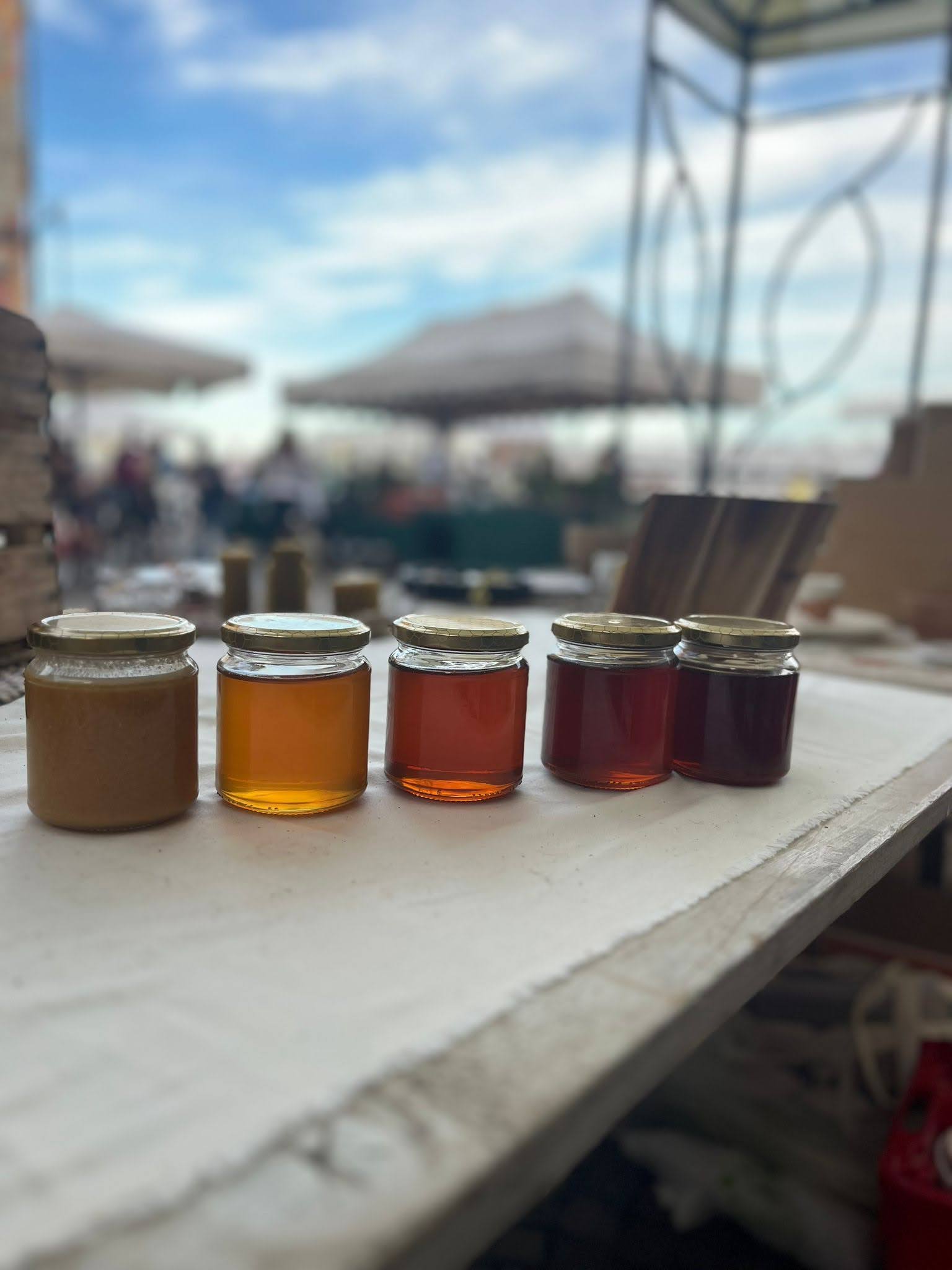 Vasetti di miele in fila con colori diversi